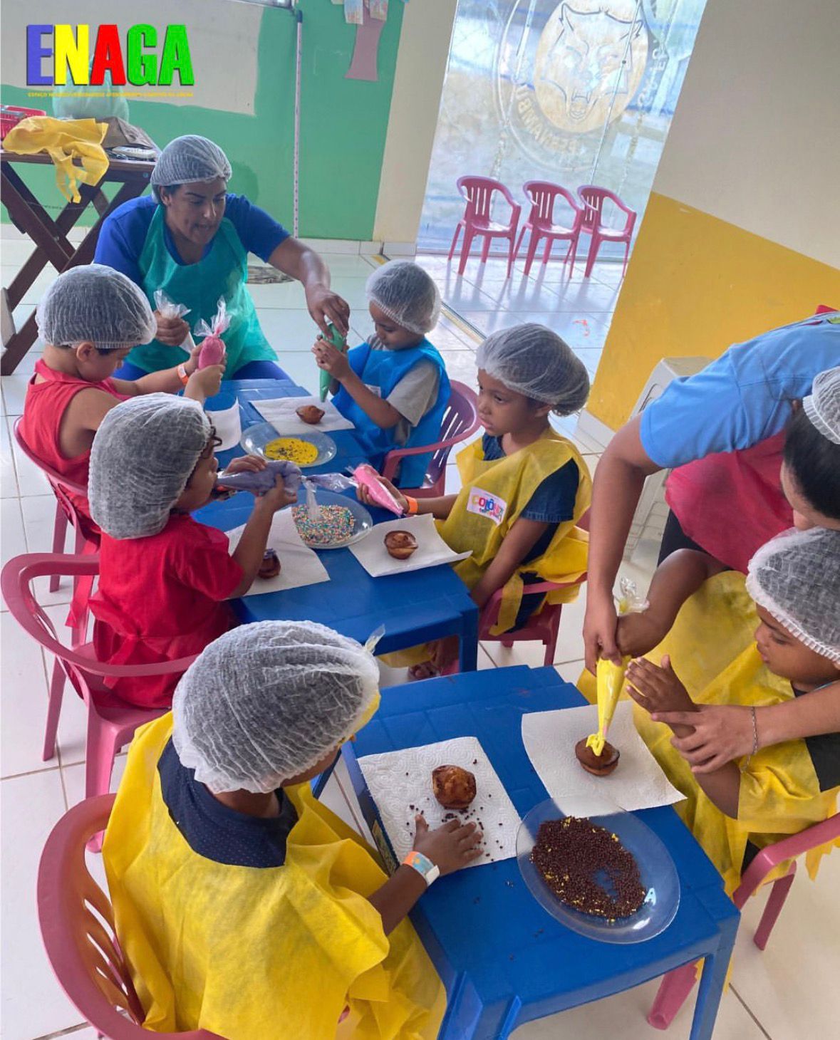 Crianças decorando cupcakes em oficina culinária do Instituto ENAGA